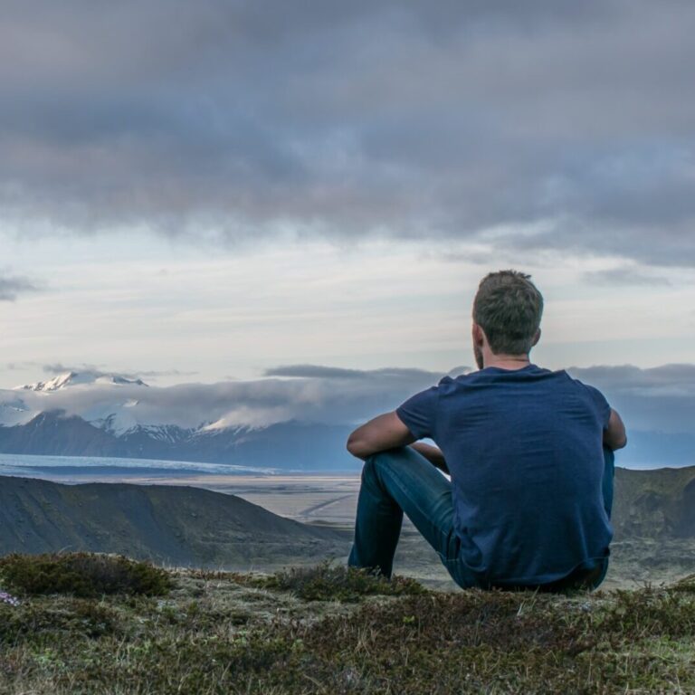 man sitting in the top of the mountain